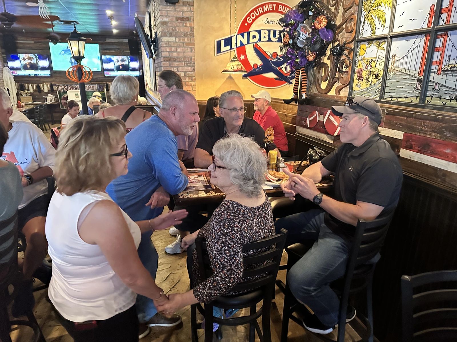Guests seated and talking at tables inside Lindburgers